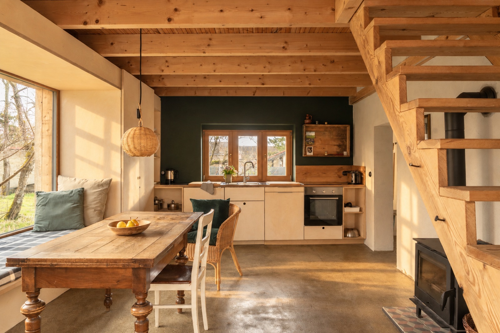 Wohn- und Küchenbereich des Apartments mit Ofen und Treppe