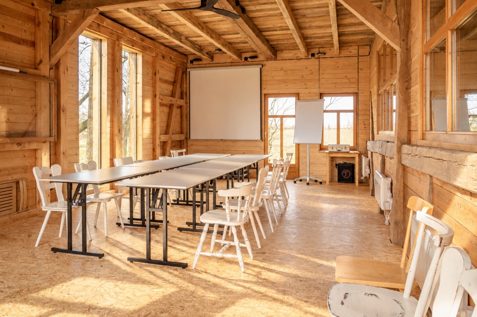 Seminarraum mit Tischen und Leinwand